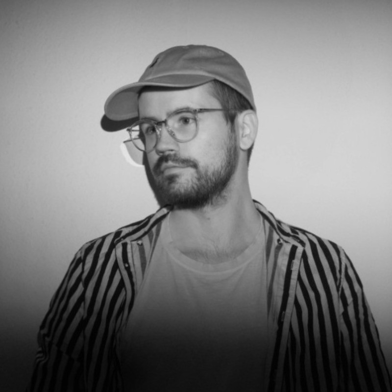 Portrait of Chris, wearing a base cap and glasses